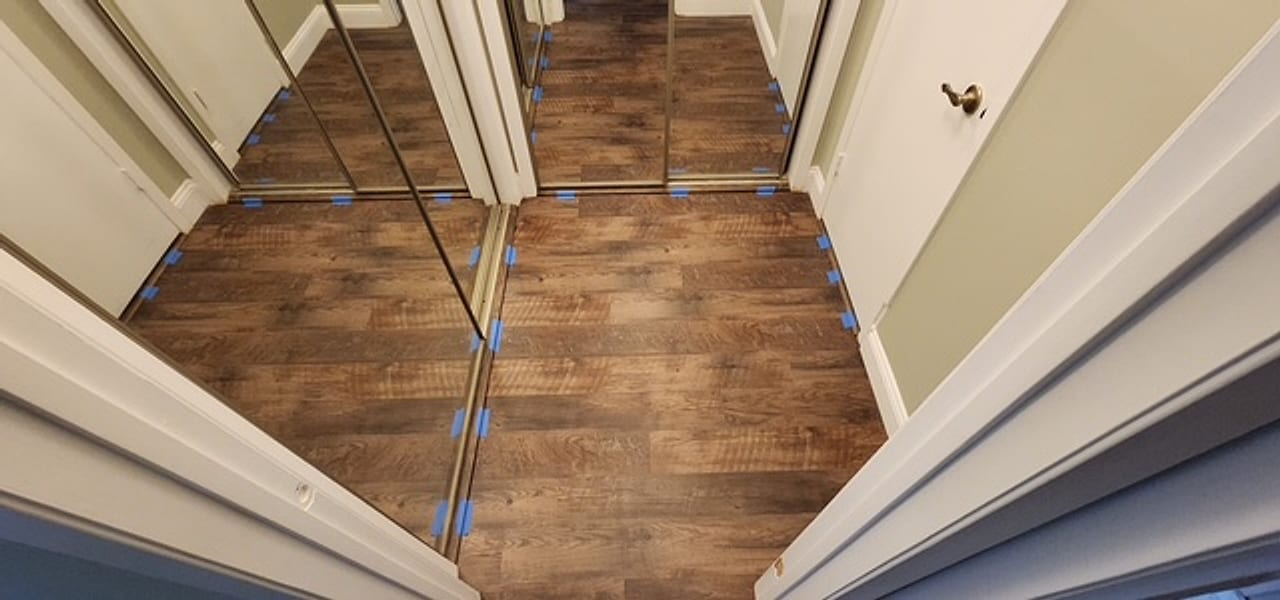 New plank flooring running into mirrored closets, expansion spacers still set, by Frankie D&rsquo;s Flooring