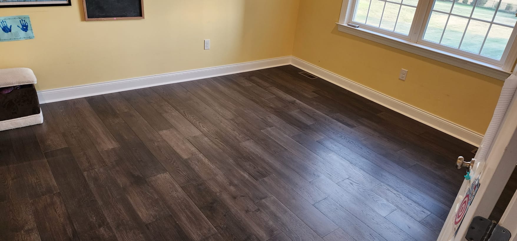 Dark hardwood floor install in a sunlit room by Frankie D&rsquo;s Flooring